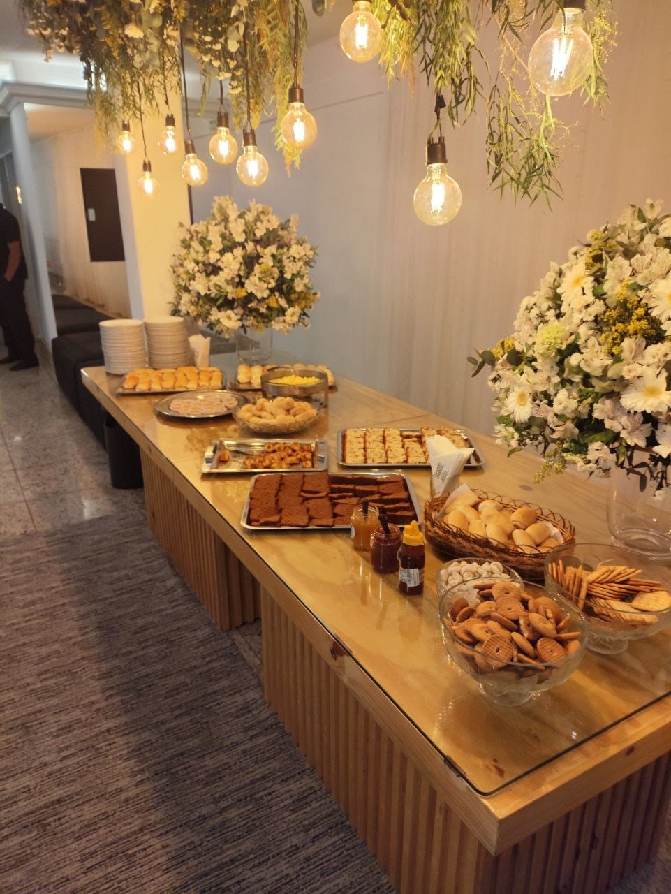 Buffet com alimentos e doces apresentados em mesa decorada