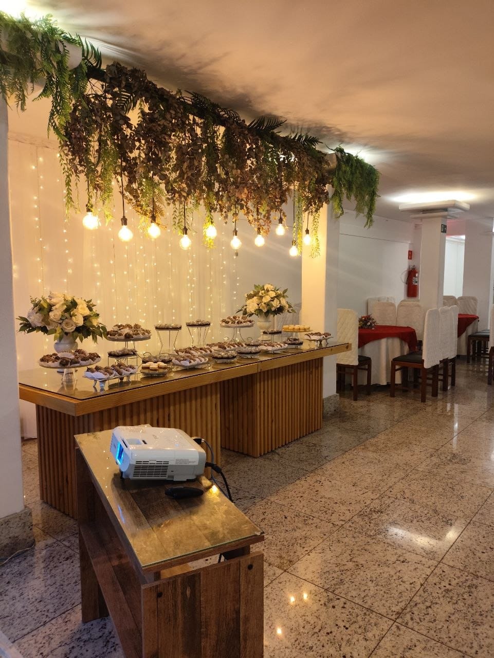 Ambiente para evento corporativo com área de projeção e mesa montada