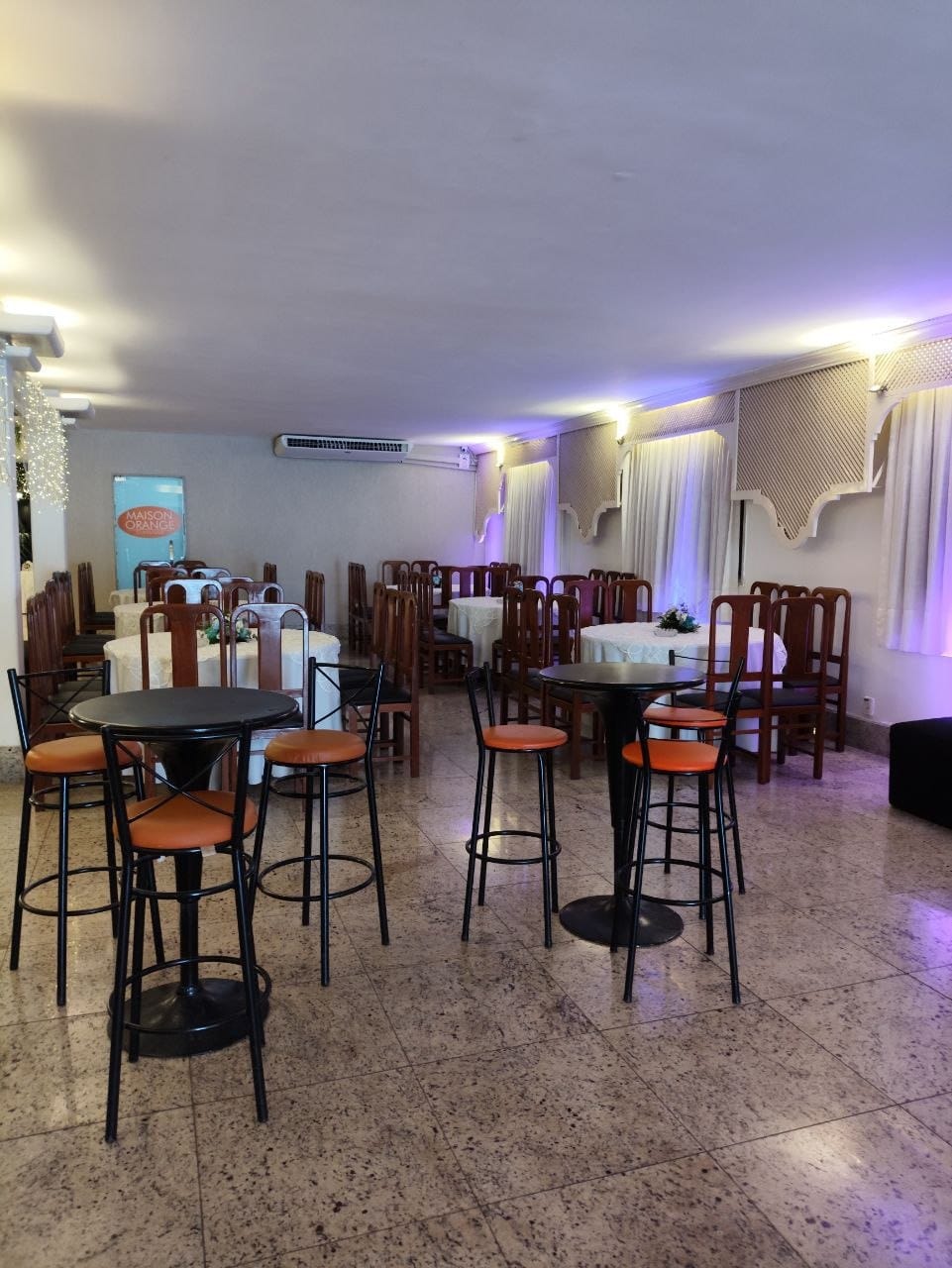 Espaço da Maison Orange Classique com mesas altas para coquetel em Vitória ES